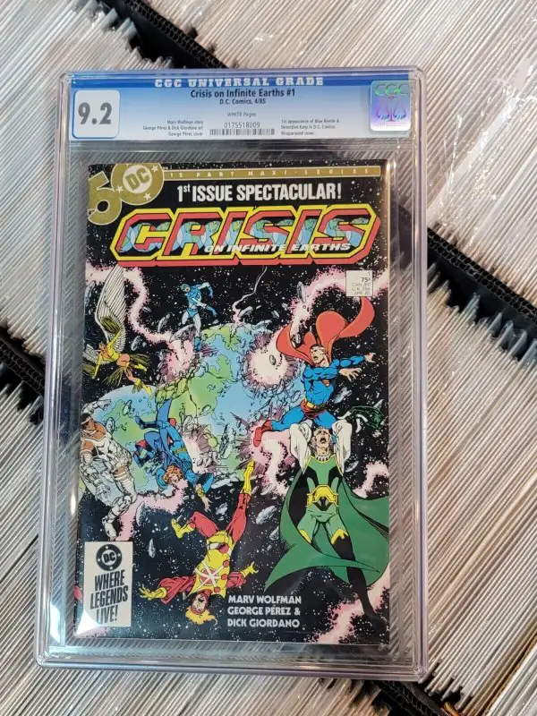 Crisis on Infinite Earths #1 (DC Comics, 1985), CGC 9.2 graded comic book, Universal Blue label — front cover in its holder